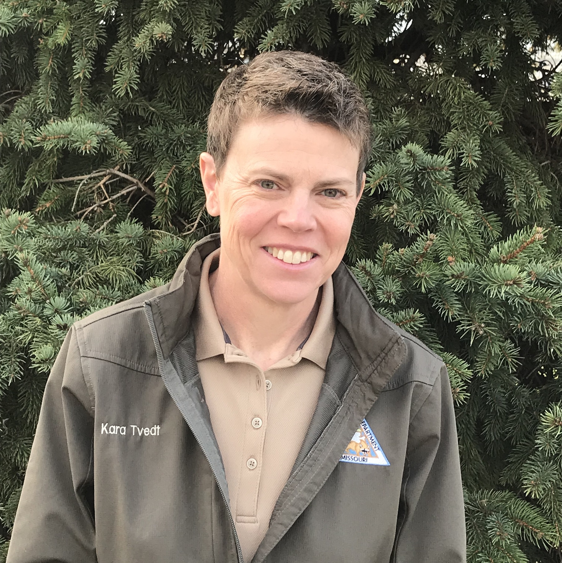 Portrait of man with plants and rocks in background.